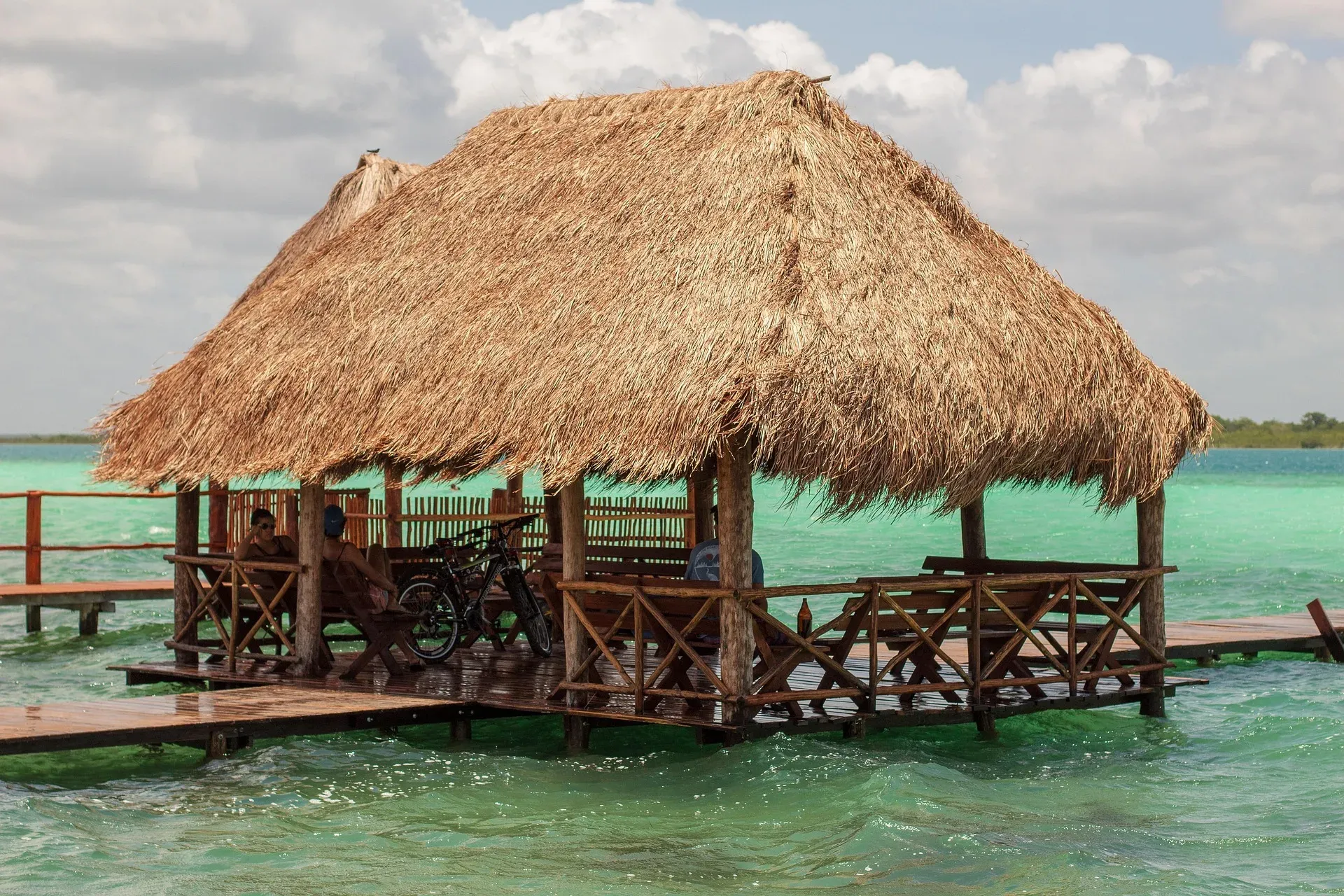 Palapa con muelle sobre las aguas verdes de la laguna de Bacalar