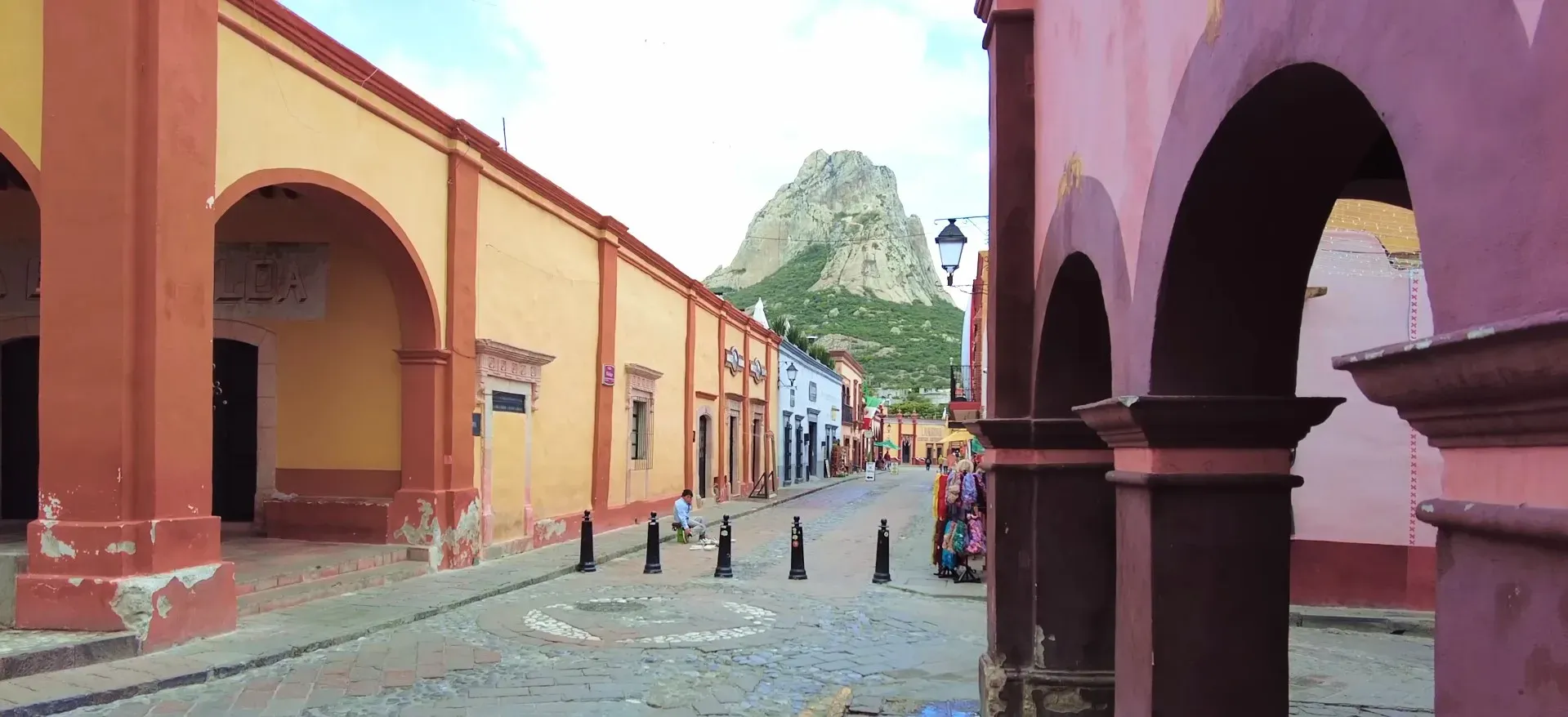 Calle colonial de Bernal con arcos y la Peña al fondo