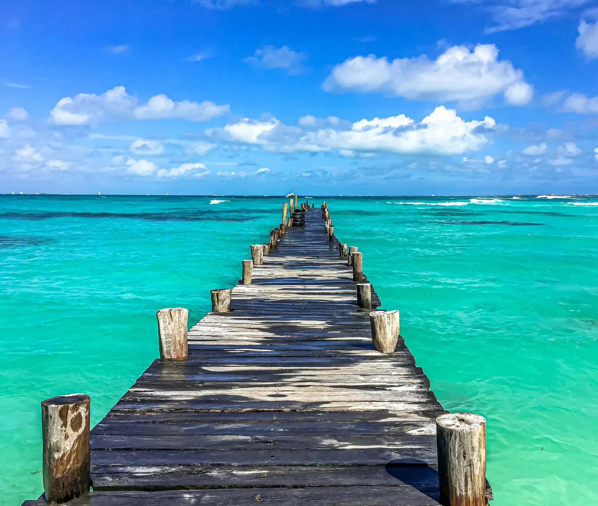 Muelle de madera sobre mar turquesa del Caribe en Cancún