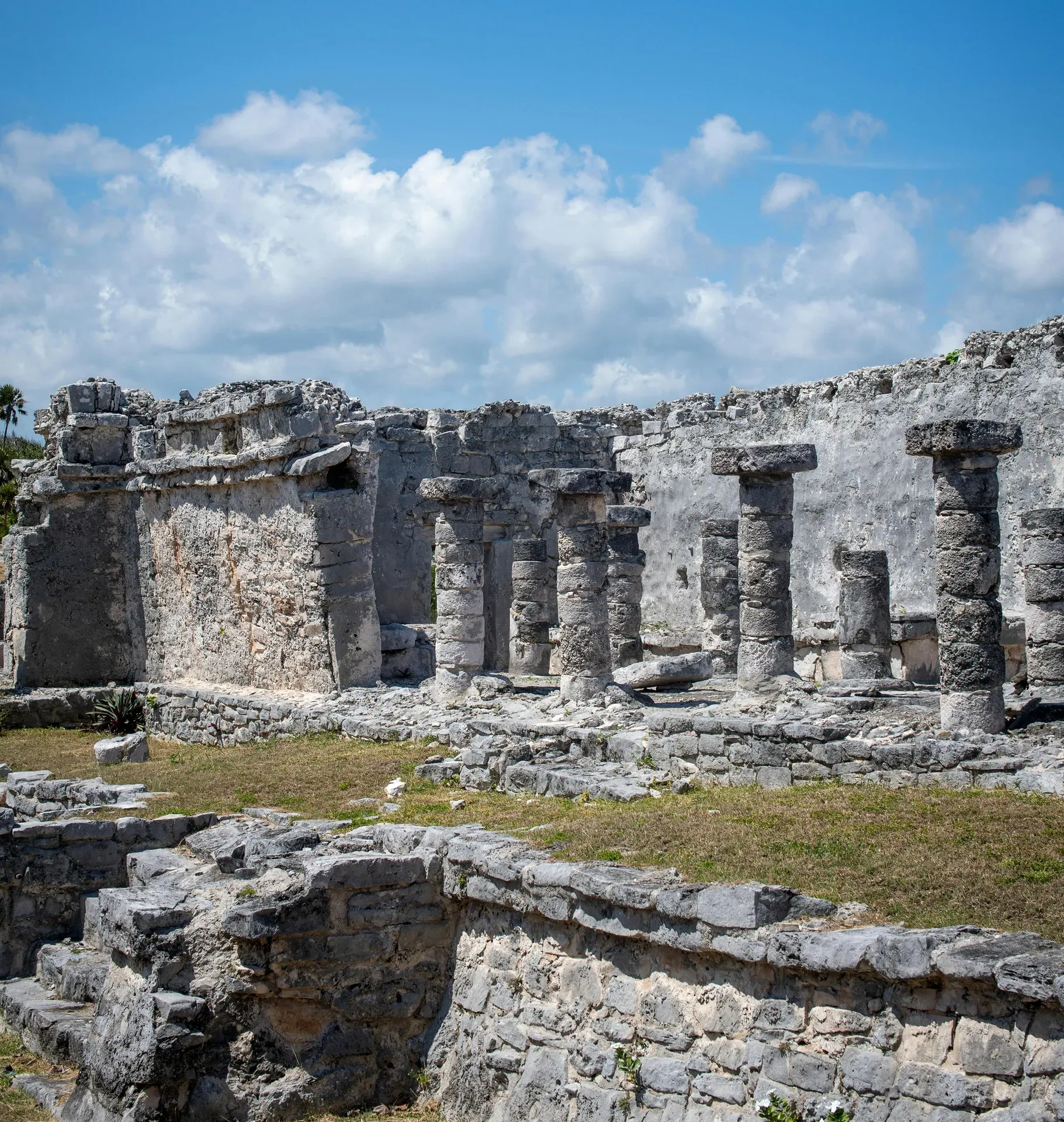 Ruinas mayas con columnas de piedra bajo cielo azul