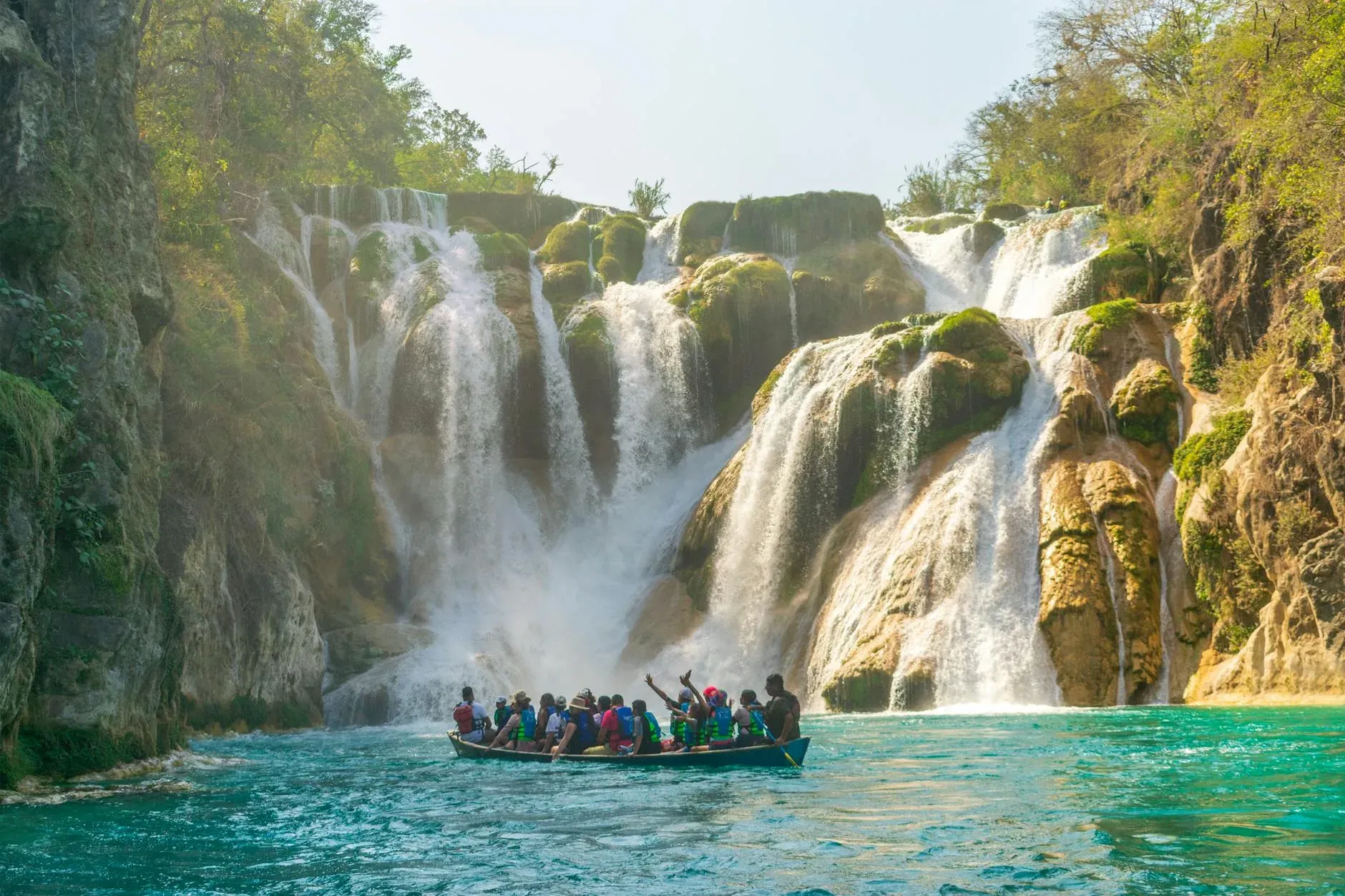 Cascada Tamul con personas en panga en el río