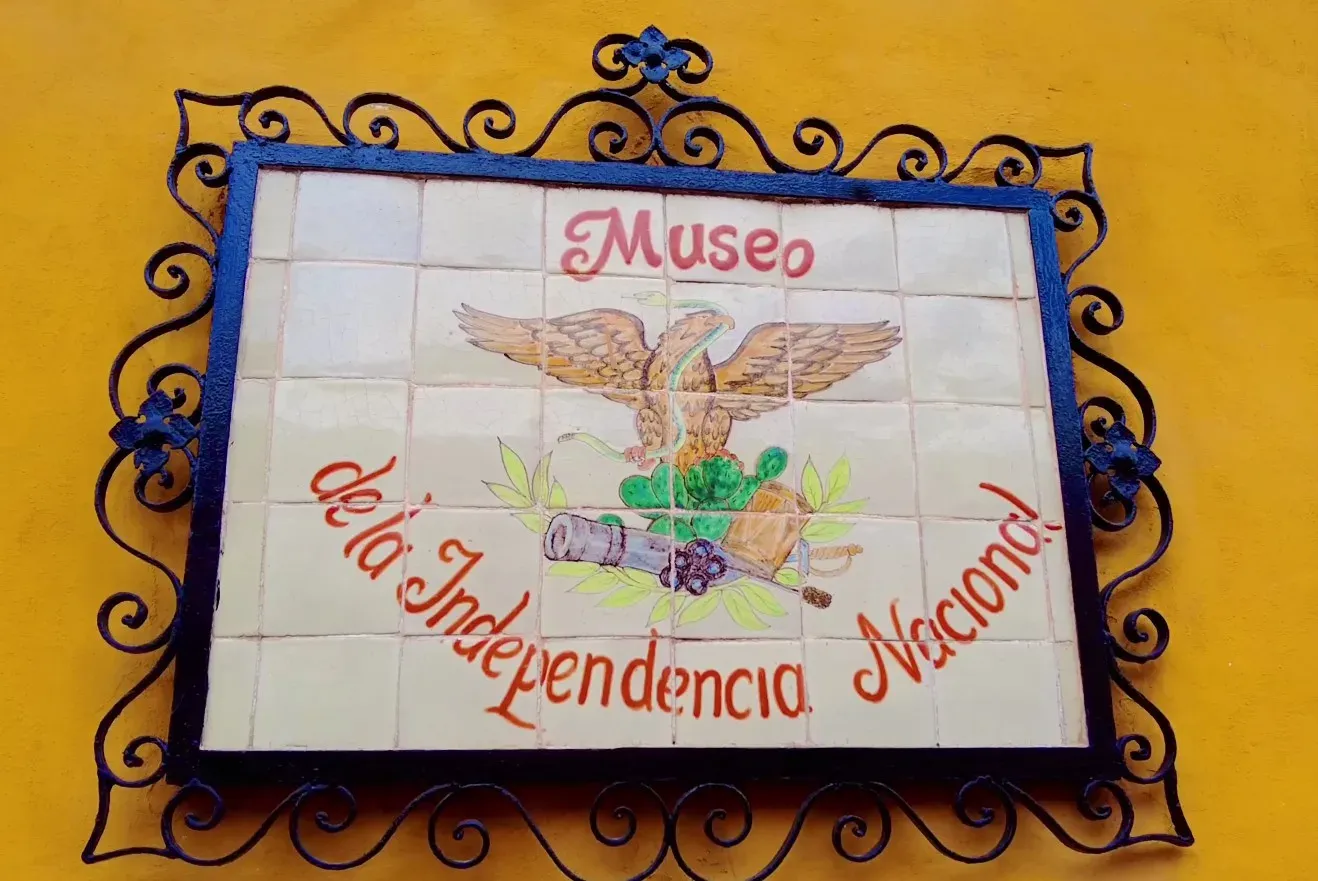 Placa de talavera del Museo de la Independencia Nacional en fachada amarilla de Dolores Hidalgo