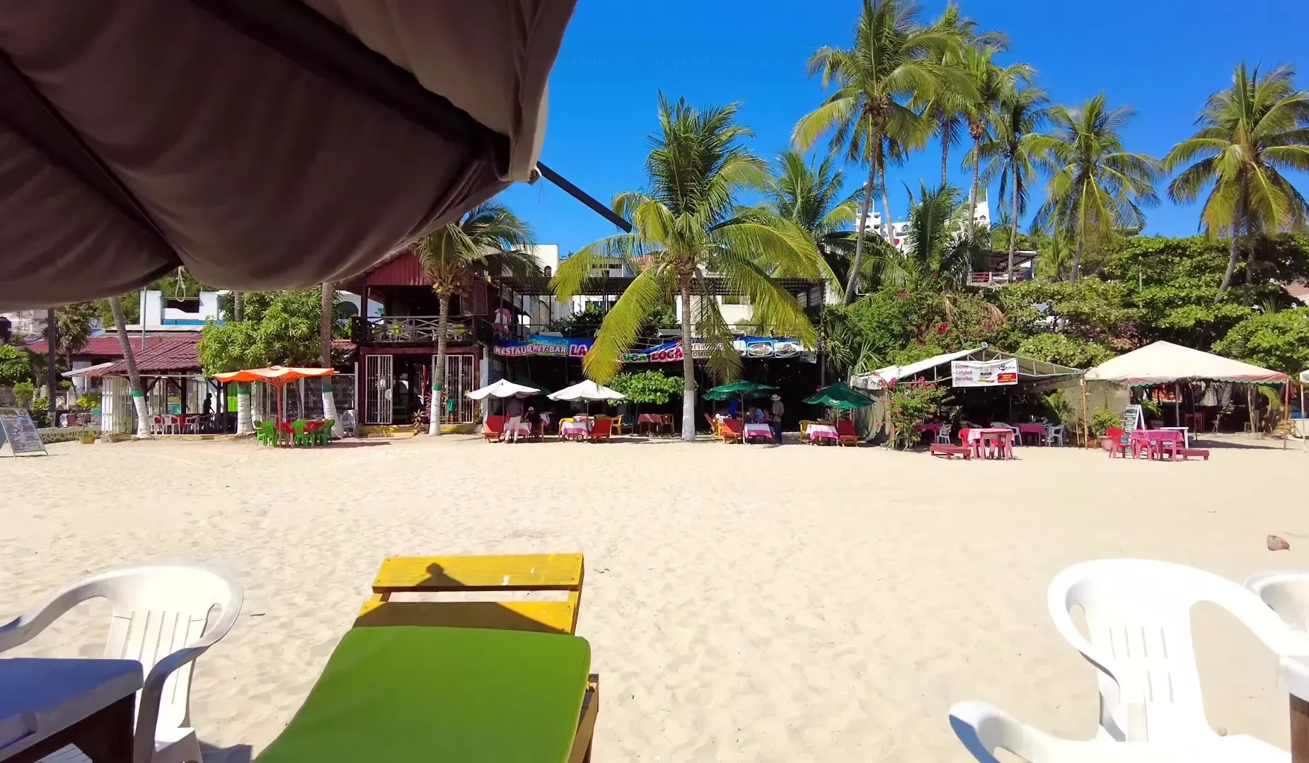 Playa La Punta con tumbonas, palapas y restaurantes al fondo