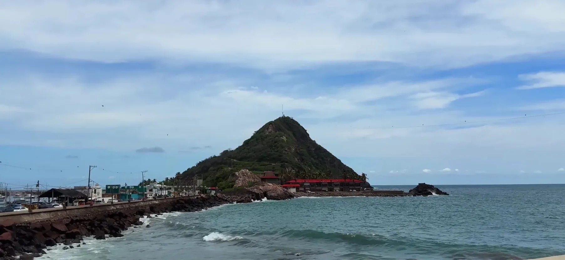 Vista panorámica del Cerro del Crestón y el faro desde el malecón con oleaje del Pacífico