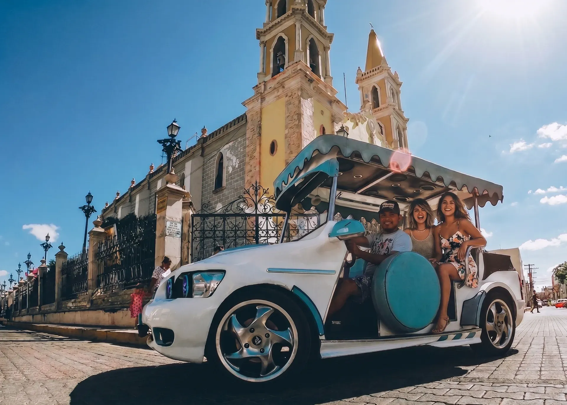Pulmonía blanca y turquesa con turistas frente a la Catedral de Mazatlán