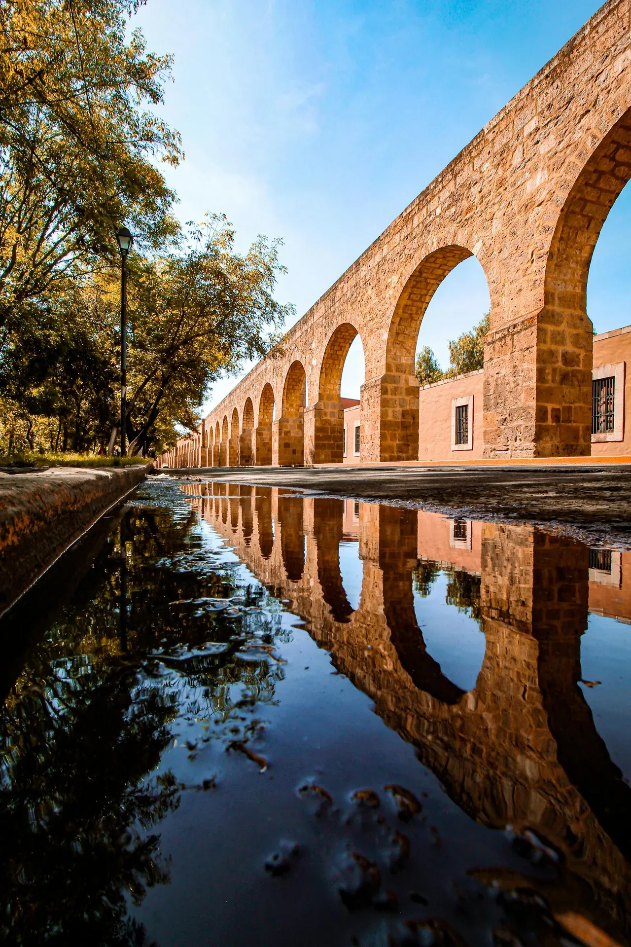Arcos de cantera rosa del Acueducto de Morelia reflejados en el agua