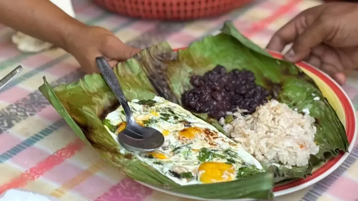 Shote con momo servido en hoja de plátano con frijoles negros y arroz blanco