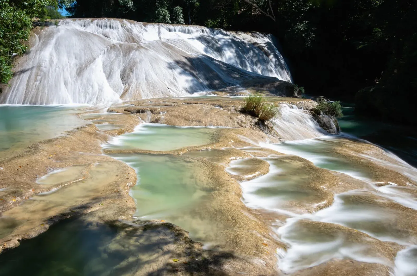 Pozas escalonadas de roca caliza con agua turquesa en las Cascadas de Roberto Barrios