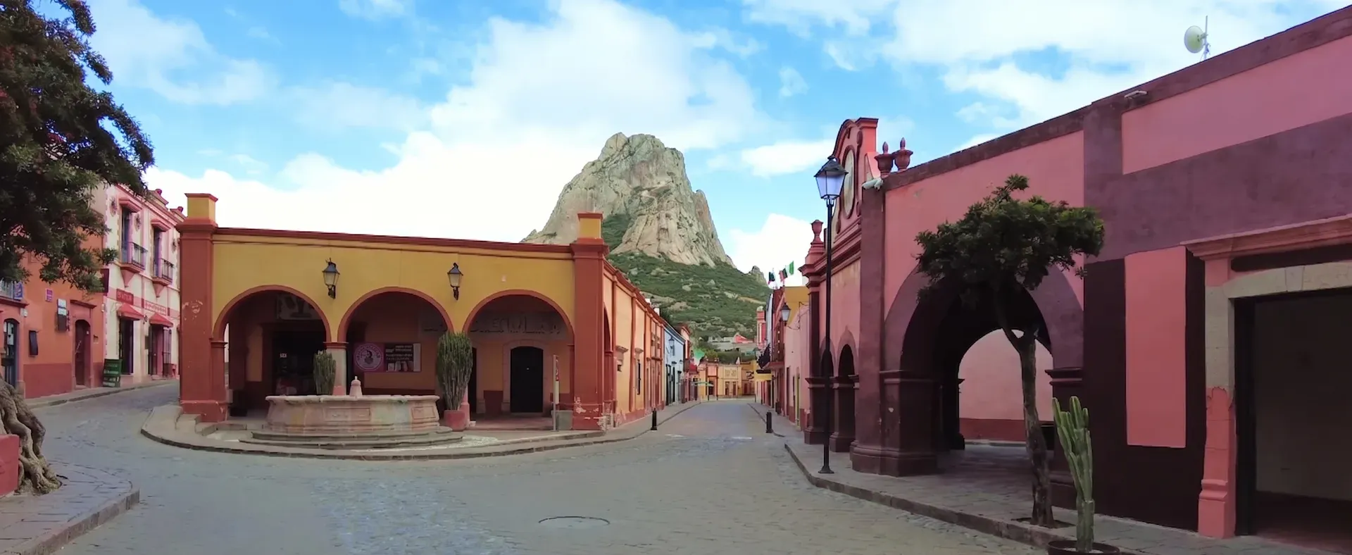 Plaza de Bernal con fuente, arcos coloniales y la Peña de Bernal al fondo