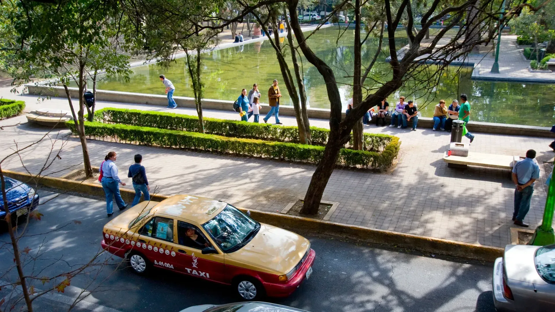 Parque Lincoln con lago, paseantes bajo los árboles y calle arbolada de Polanco