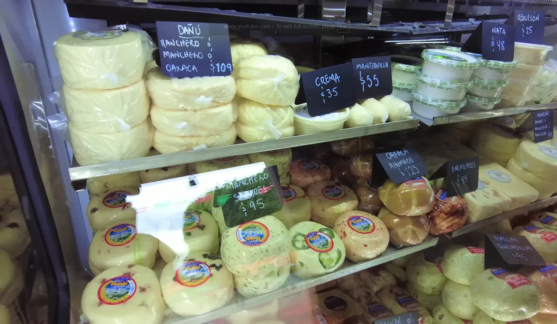 Vitrina de quesos artesanales con precios en Bernal