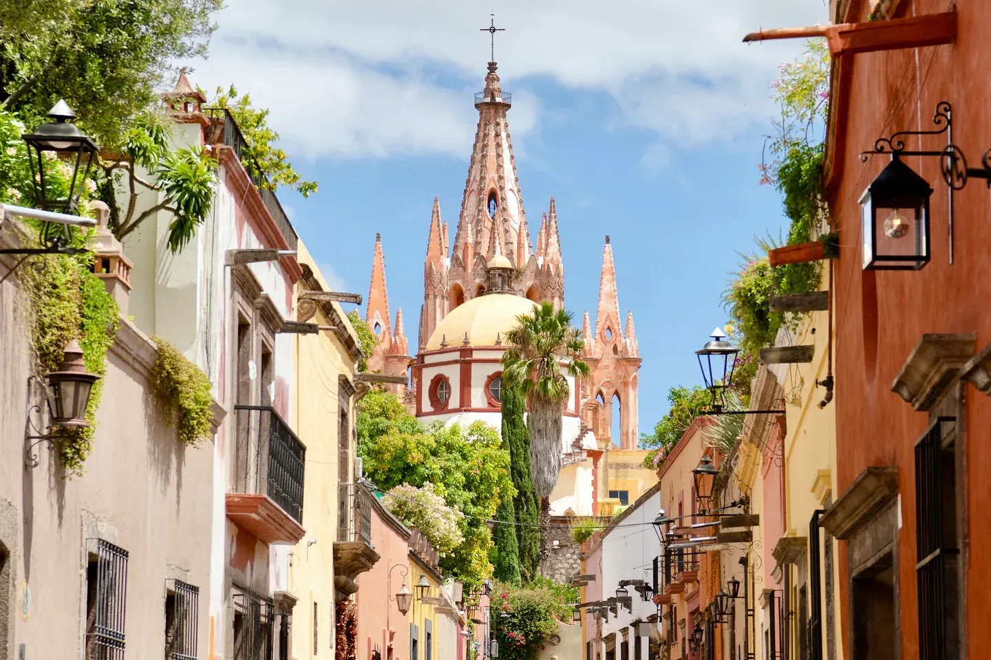 Fachada neogotica de cantera rosa de la Parroquia vista desde una calle colonial