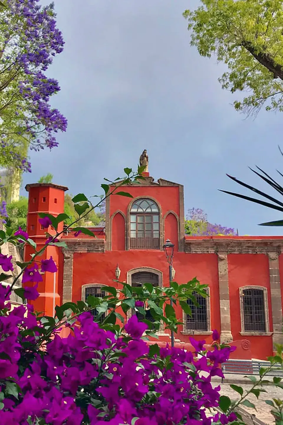 Casona colonial roja rodeada de buganvilias en San Miguel de Allende