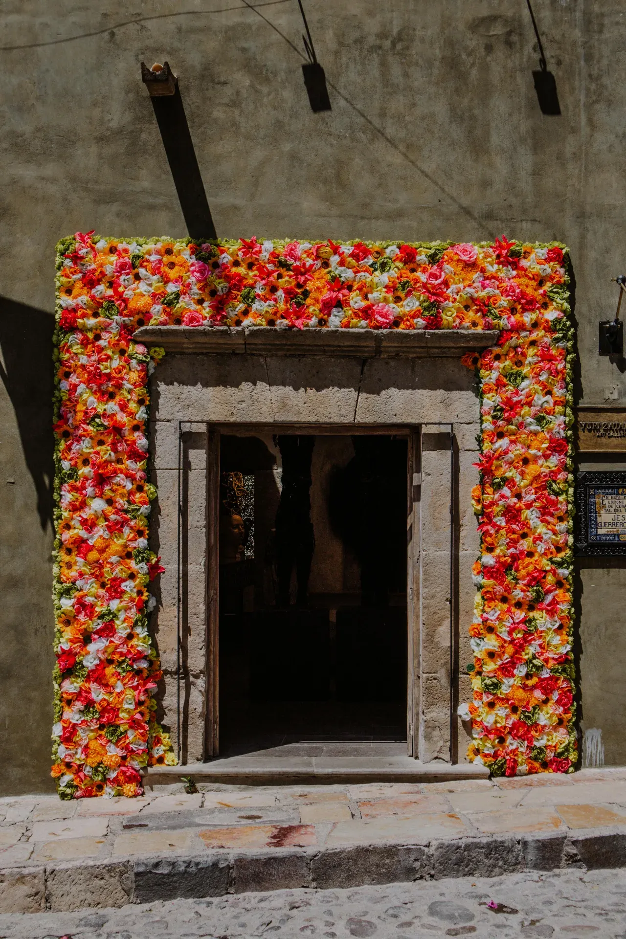 Entrada con arco de flores coloridas en la Fabrica La Aurora