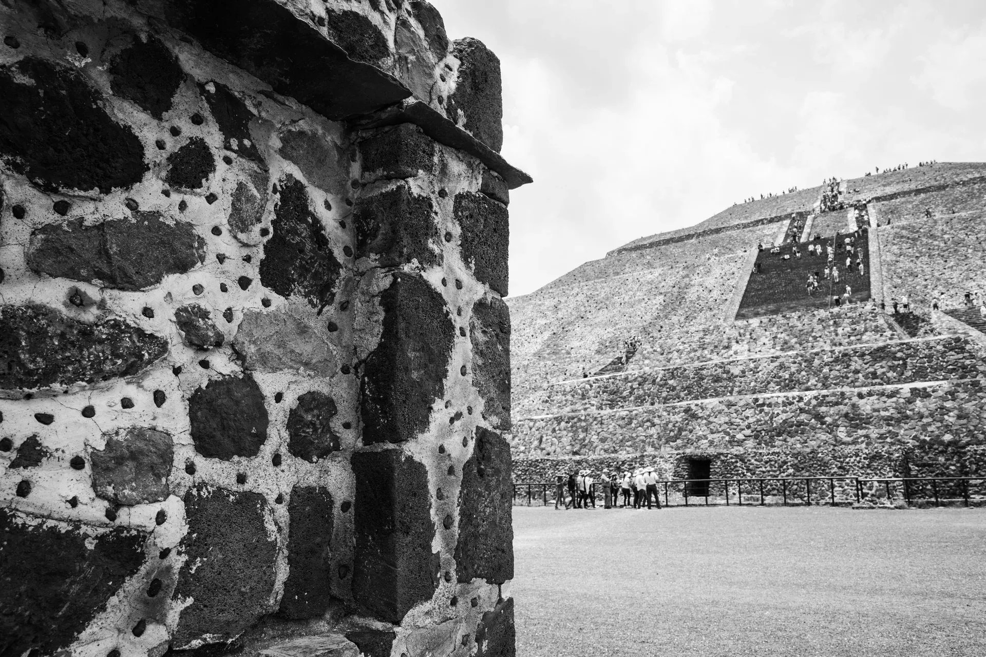 Detalle de piedra tallada con piramide de fondo en Teotihuacan