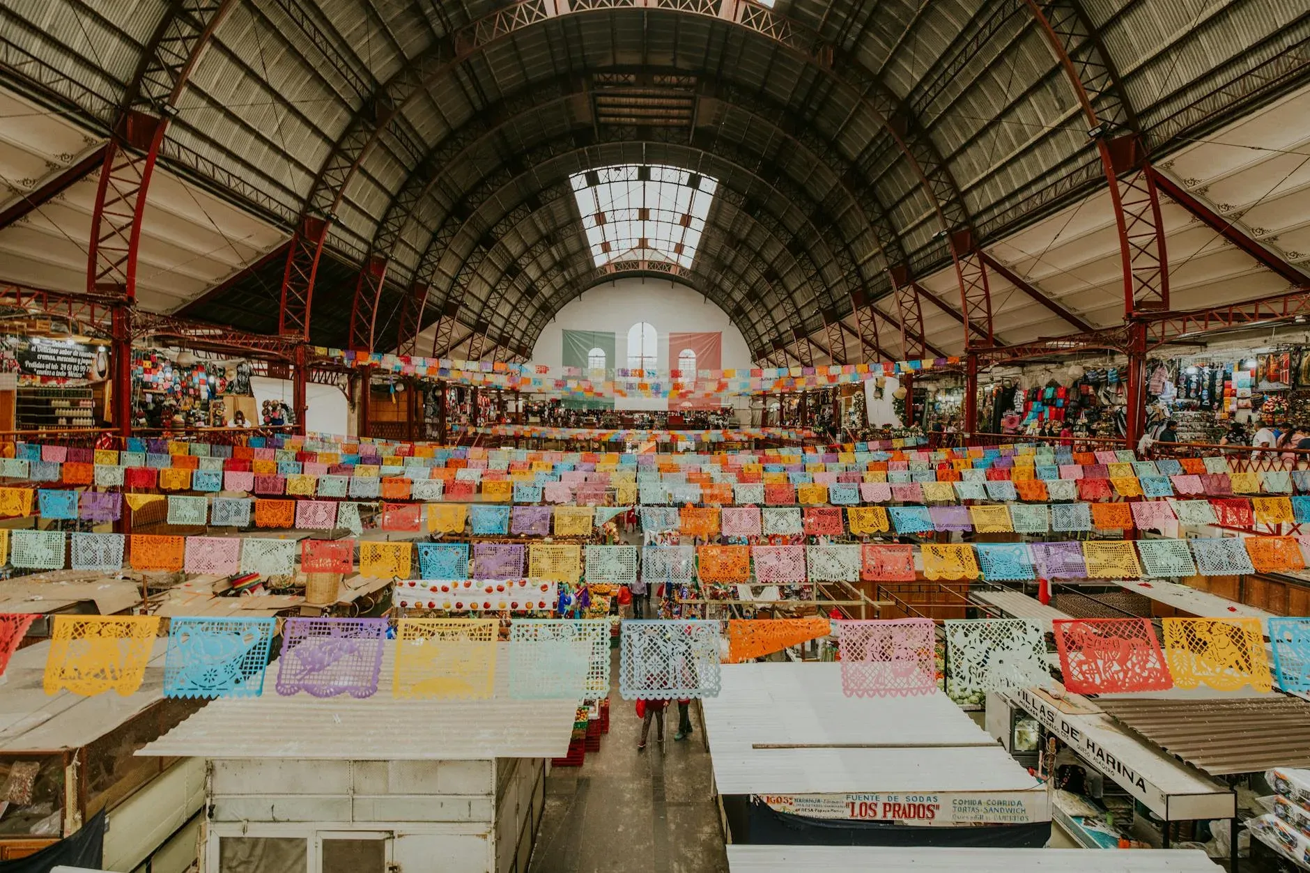 Interior de mercado tradicional con puestos coloridos y productos locales
